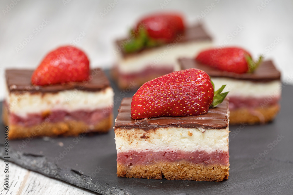 A piece of chocolate and vanilla cake with strawberries