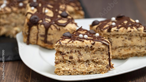 Chocolate cake with nut cream on a wooden table.