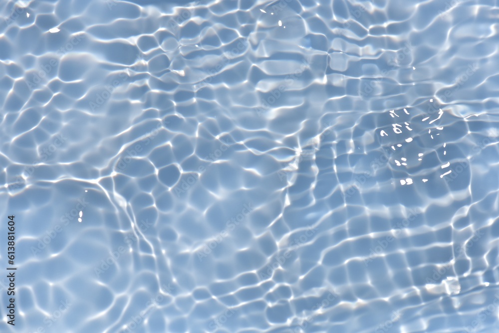 Fototapeta premium Blue water with ripples on the surface. Defocus blurred transparent blue colored clear calm water surface texture with splashes and bubbles. Water waves with shining pattern texture background.