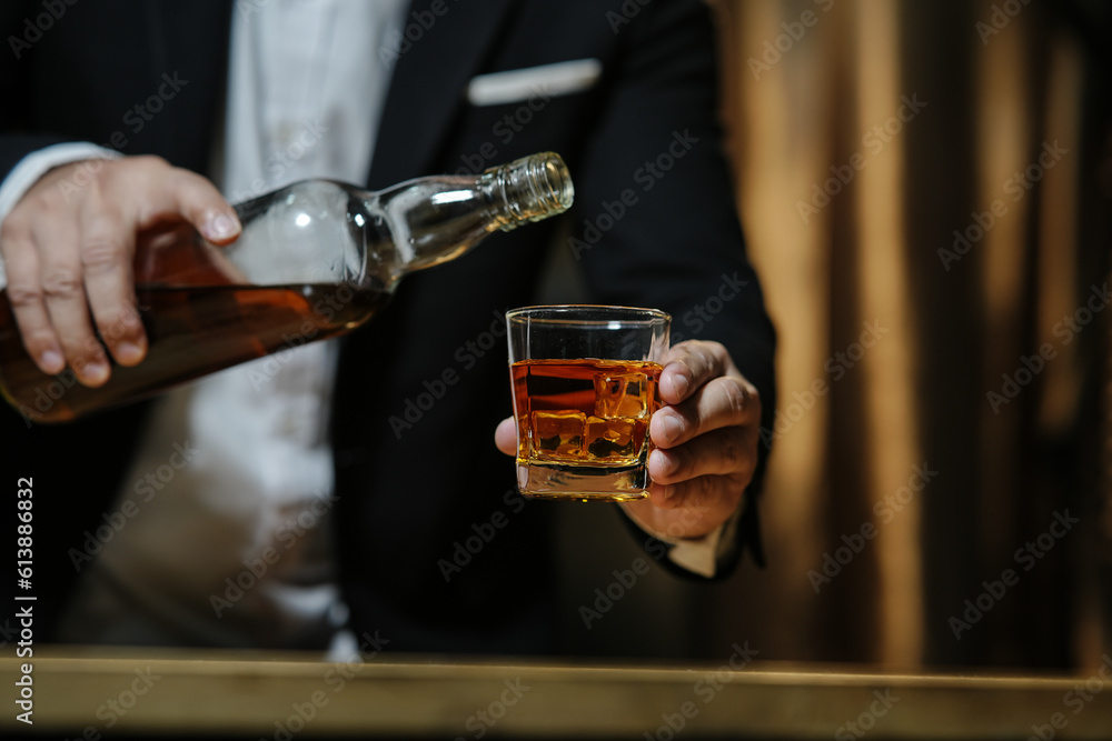 Barman pouring whiskey whiskey glass celebrate whiskey on a friendly party in  restaurant