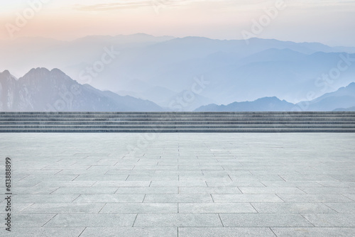 Empty square pavement and mountain landscape in sunny daytime