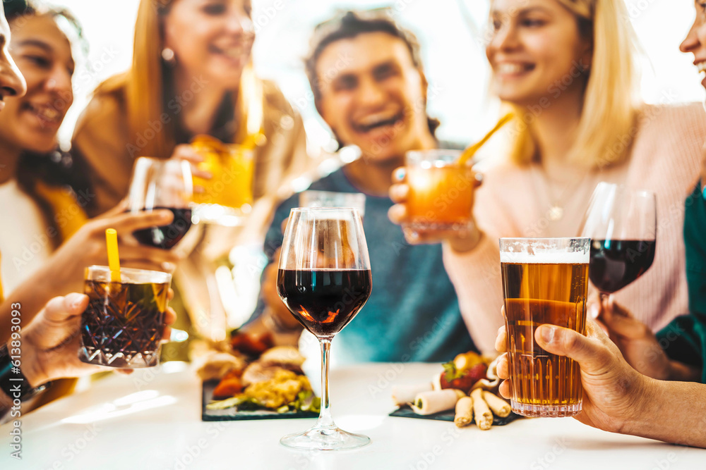 Happy friends enjoying happy hour sitting at bar restaurant table - Young people having fun hanging out on weekend day - Food and beverage concept with guys and girls drinking alcohol together Happy friends enjoying happy hour sitting at bar restaurant table - Young people having fun hanging out on weekend day - Food and beverage concept with guys and girls drinking alcohol together