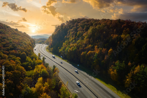 I-40 freeway road leading to Asheville in North Carolina thru Appalachian mountains with yellow fall forest and fast moving trucks and cars. Concept of high speed interstate transportation
