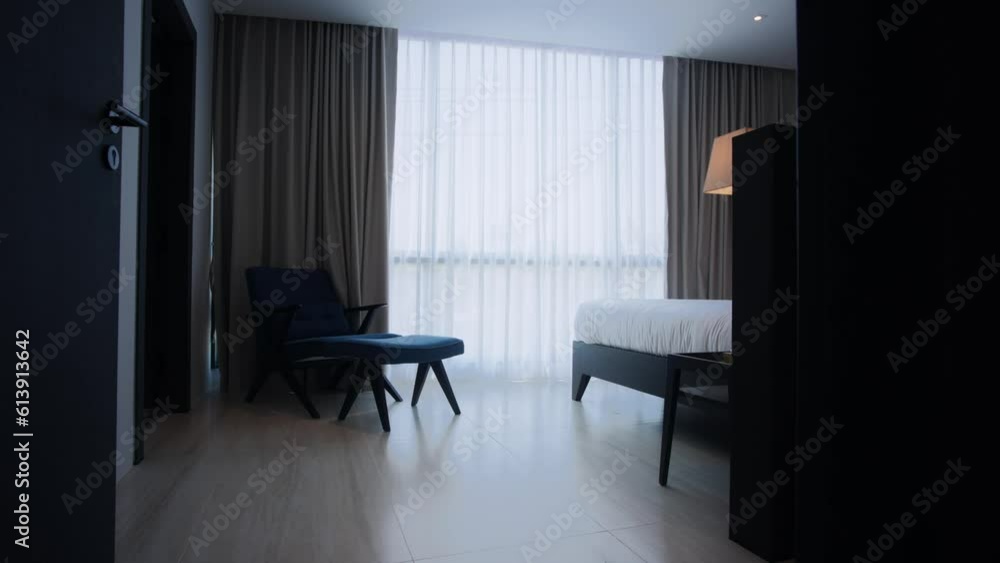 The video camera moves in into the bedroom, where there is a bed, sofa and sheer curtains. It's an interior video. The video camera moves in into the bedroom, where there is a bed, sofa and sheer curtains. It's an interior video.