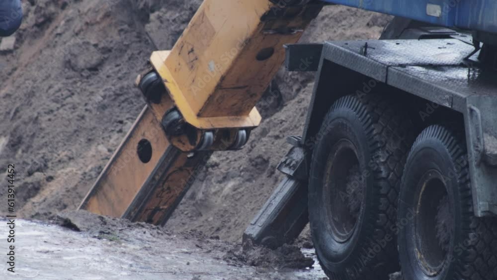 A worker in overalls watches the process of digging a hole with an excavator machine. Chassis and emphasis of the excavator, industry A worker in overalls watches the process of digging a hole with an excavator machine. Chassis and emphasis of the excavator, industry