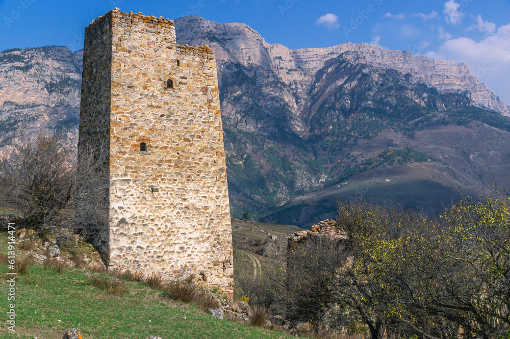 An ancient stone city in the Republic of Ingushetia. Historical structures for protection from attacks. Fortress towers made of stones against the background of mountains and blue sky. An ancient stone city in the Republic of Ingushetia. Historical structures for protection from attacks. Fortress towers made of stones against the background of mountains and blue sky.