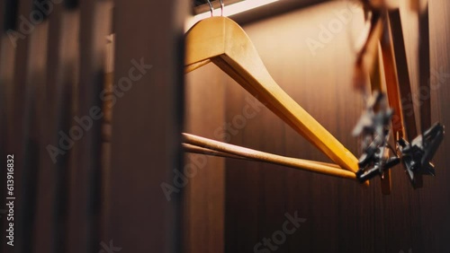 .Hangers in a wooden wardrobe inside the hotel. When opening, there will be a light inside the cabinet that automatically lights up.