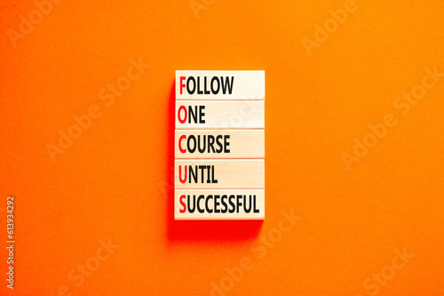 FOCUS follow one course until successful symbol. Concept words FOCUS follow one course until successful on wood block. Orange background. Business FOCUS follow one course until successful concept.