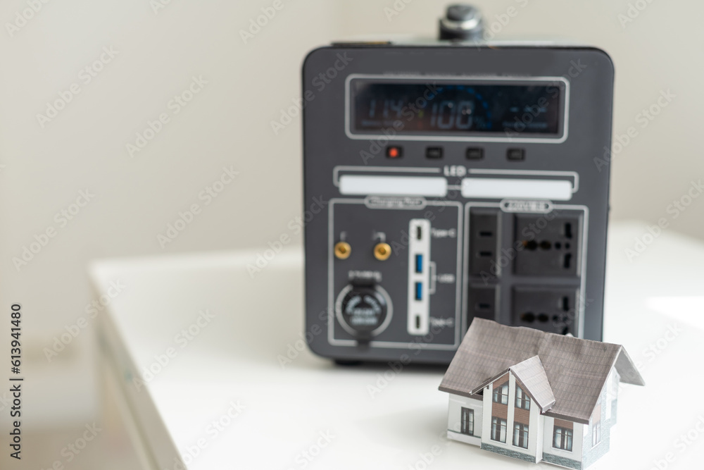 Fototapeta premium Portable power station charging gadgets on table in room. Home