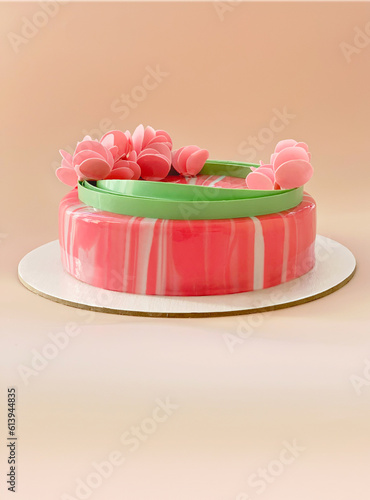 festive pink mousse cake with decor on beige background. copy space.