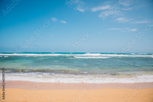 The sand and water of Wailua Beach on the island of Kauai, Hawaii on a clear blue day with no people
