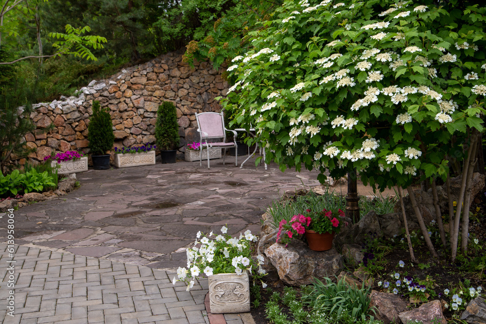 Fragment of the park with garden furniture and plants. A place for relaxation in a big city. Landscaping.