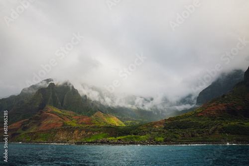 Fog over the mountains of the NaPali Coastline on the island of Kauai, Hawaii on a cloudy day from a sunsets boat cruise