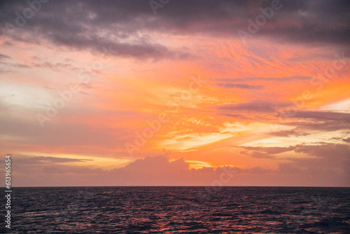 Beautiful pastel pink and orange sunset over the ocean near the Na Pali coastline on the island of Kauai, Hawaii