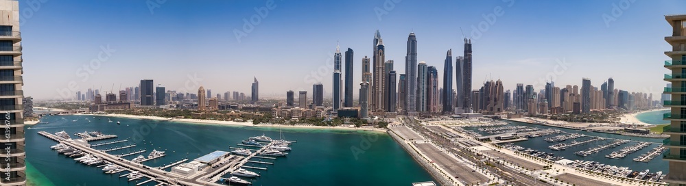 Panoramic aerial view of Dubai beachfront modern skyscrapers sunshine summer day. Backdrop of cityscape UAE skyscrapers and new towers. Construction and modern architecture concept. Copy ad text space