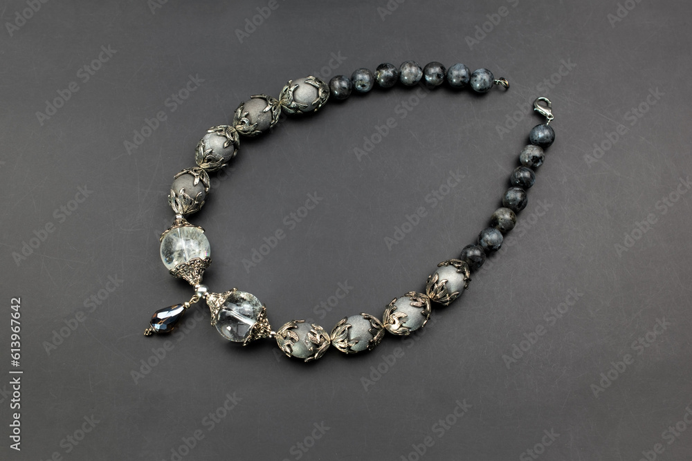 Gray gemstone crystal beads necklace on black, unique handmade jewelry background Gray gemstone crystal beads necklace on black, unique handmade jewelry background