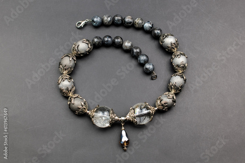 Gray gemstone crystal beads necklace on black, unique handmade jewelry background