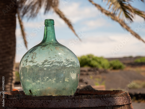 Old vintage glass bottle on the barrel. 