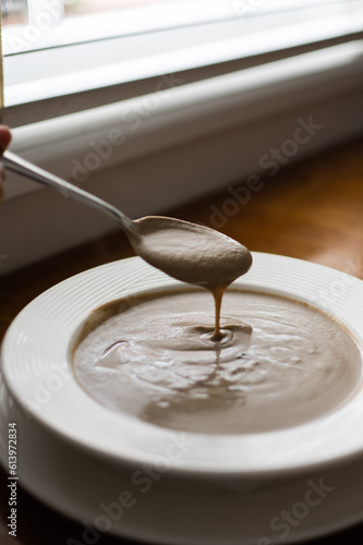 Creamy Truffle Mushroom Soup with Spoon by a Window