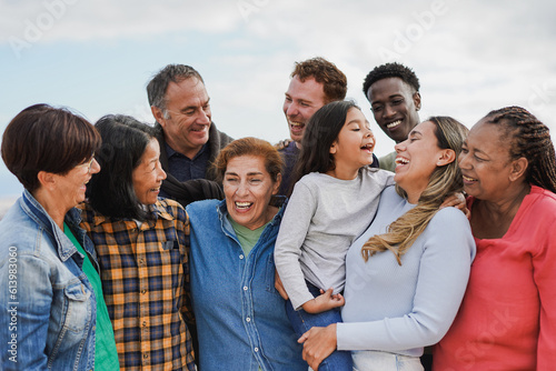 Crowd of multi generational people hugging each other outdoor - Multiracial friends having fun together
