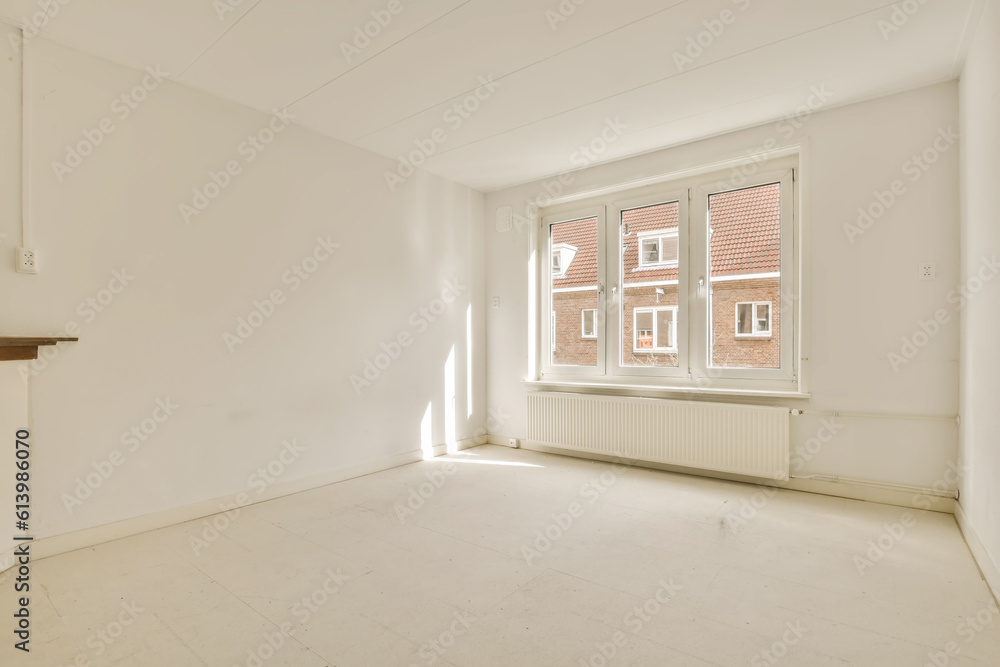 an empty living room with white walls and floor to the right there is a fire place in front of the window an empty living room with white walls and floor to the right there is a fire place in front of the window