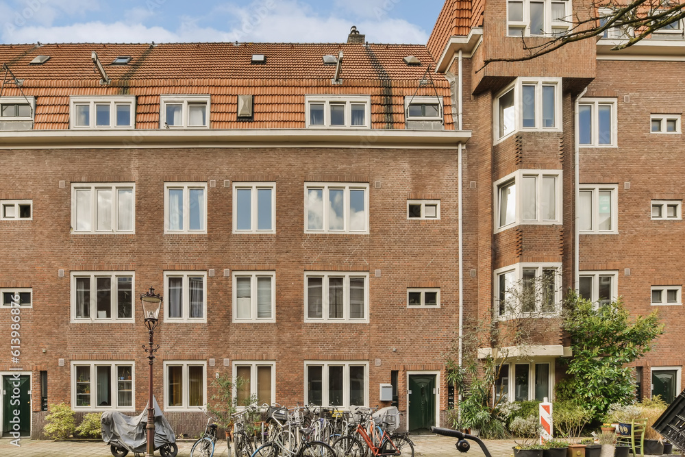 Obraz premium an apartment building with bicycles parked in the street next to each other buildings on a sunny day - stock photo