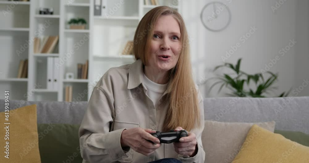 Beautiful mature woman playing online video games at home. Beautiful mature woman playing online video games at home.