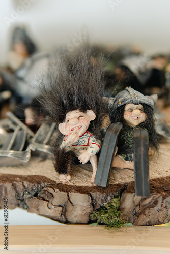 Figures of a trolls sitting on the piece of wood. Symbol of Norway