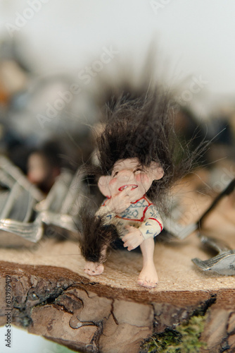 Figures of a trolls sitting on the piece of wood. Symbol of Norway