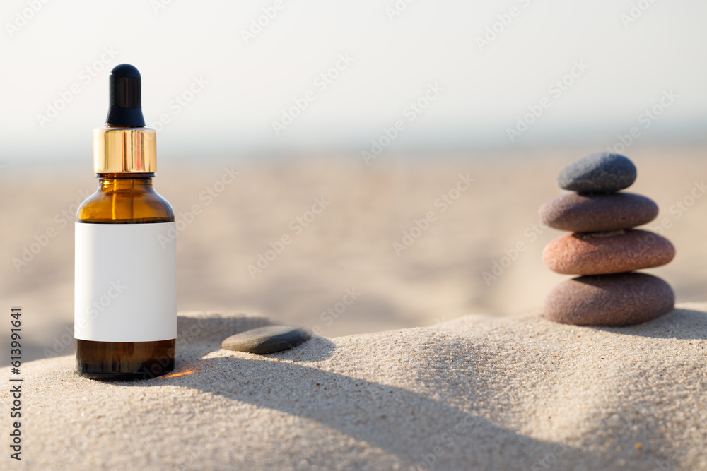 Concept of natural calming product at beach. Bottle with blank label. Pebble and bottle. Concept of natural calming product at beach. Bottle with blank label. Pebble and bottle.