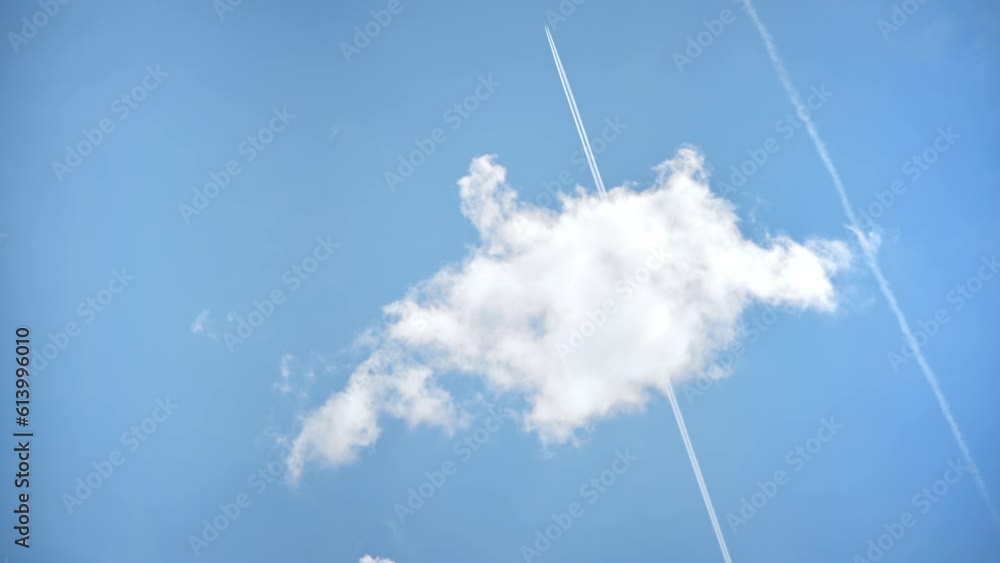 View of the partly cloudy sky with flying plane in the distance leaving a trail View of the partly cloudy sky with flying plane in the distance leaving a trail