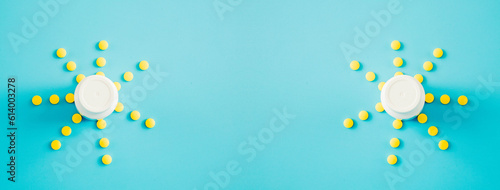 A sun of yellow pills and bottle on a blue background