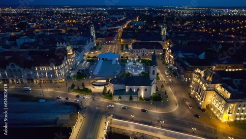 Areal drone view of the Unirii Square in Oradea downtown at night, Romania. King Ferdinand I statue, Saint Ladislaus Church, Town Hall and other historical buildings, illumination photo