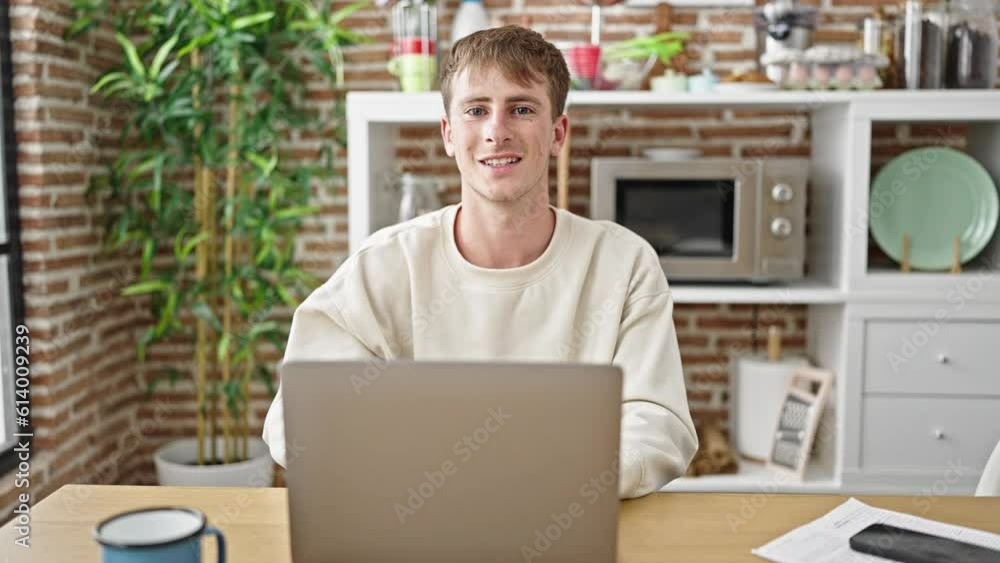 Young caucasian man using laptop sitting on table at dinning room Young caucasian man using laptop sitting on table at dinning room