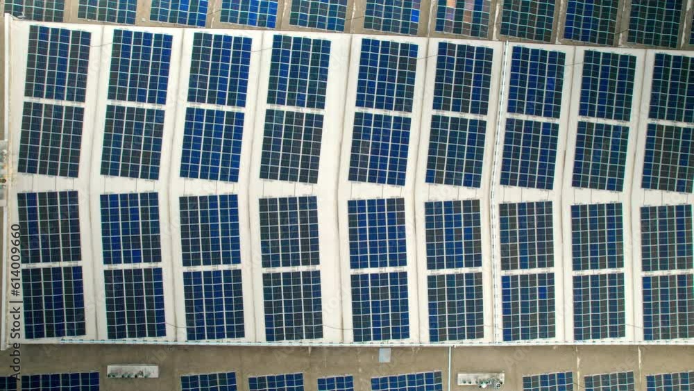 Aerial drone view of a building with fully covered roof with solar panels