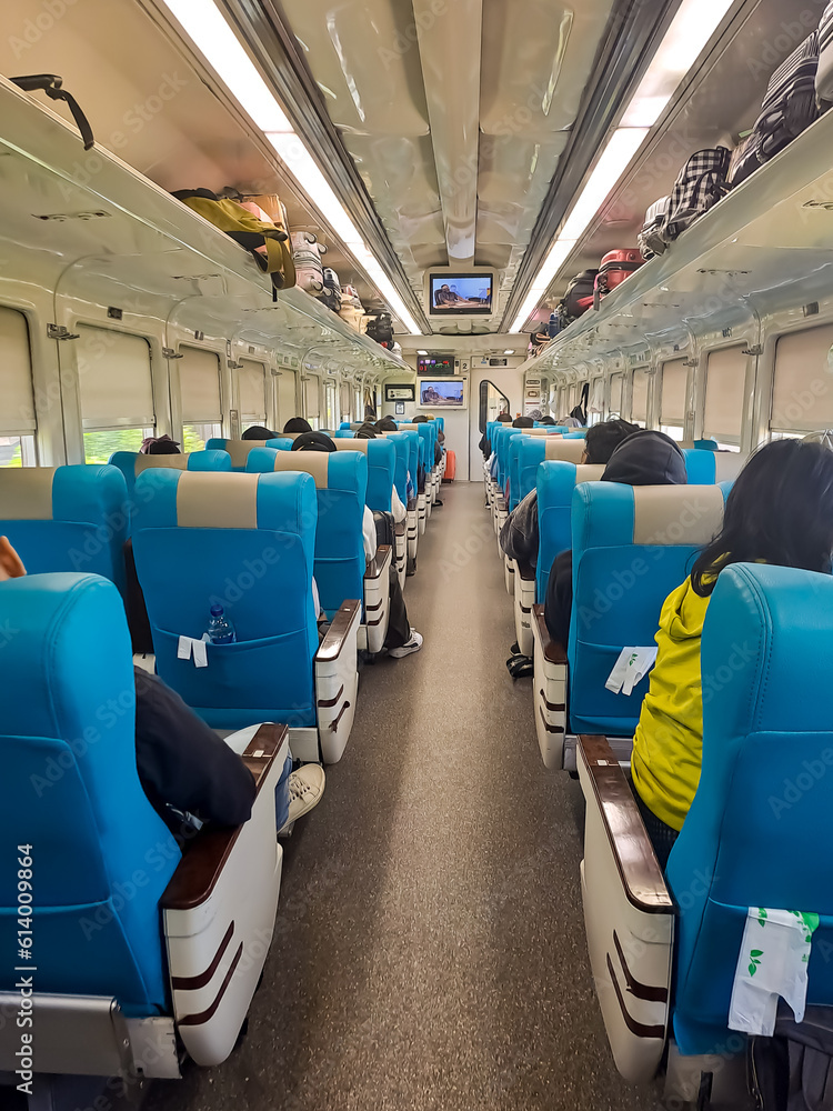 Executive class train interior with passenger seats, air conditioning and light, full of passengers and the luggages. Taken from the rear side Executive class train interior with passenger seats, air conditioning and light, full of passengers and the luggages. Taken from the rear side
