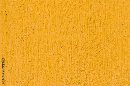 Yellow grunge wall for texture background, vibrant color, selective focus
