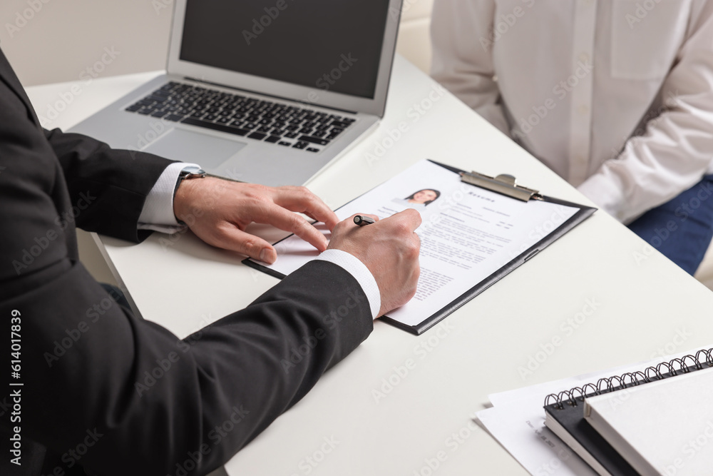 Human resources manager reading applicant's resume in office, closeup Human resources manager reading applicant's resume in office, closeup