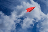 White clouds and paper airplane flying in blue sky on sunny day. Space for text