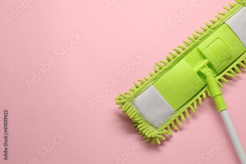 Mop with plastic handle on pink background, top view. Space for text