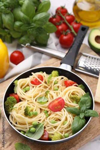 Delicious pasta primavera in frying pan and ingredients on table, closeup