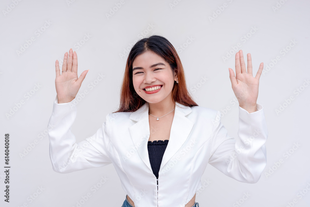 A smiling and cheerful young woman with both arms raised in surrender. Isolated on a white background. A smiling and cheerful young woman with both arms raised in surrender. Isolated on a white background.