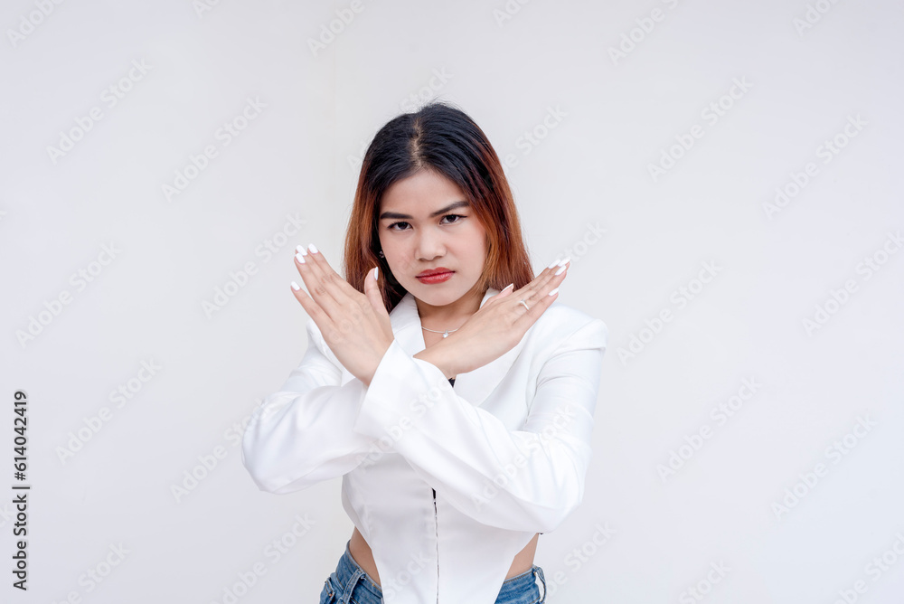 A serious and unimpressed young woman doing an x-sign with her arms. Isolated on a white background. A serious and unimpressed young woman doing an x-sign with her arms. Isolated on a white background.