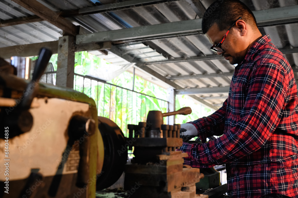 Asian technician working with drilling holes in wood machine in woodwork factory. Concept of skill in working job with machine. Asian technician working with drilling holes in wood machine in woodwork factory. Concept of skill in working job with machine.