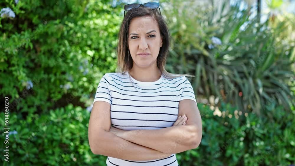 Middle eastern woman standing with serious expression and crossed arms at park Middle eastern woman standing with serious expression and crossed arms at park