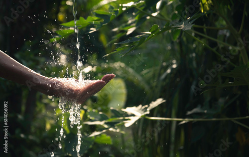 closeup water flow to hand of women for nature concept on the garden background.