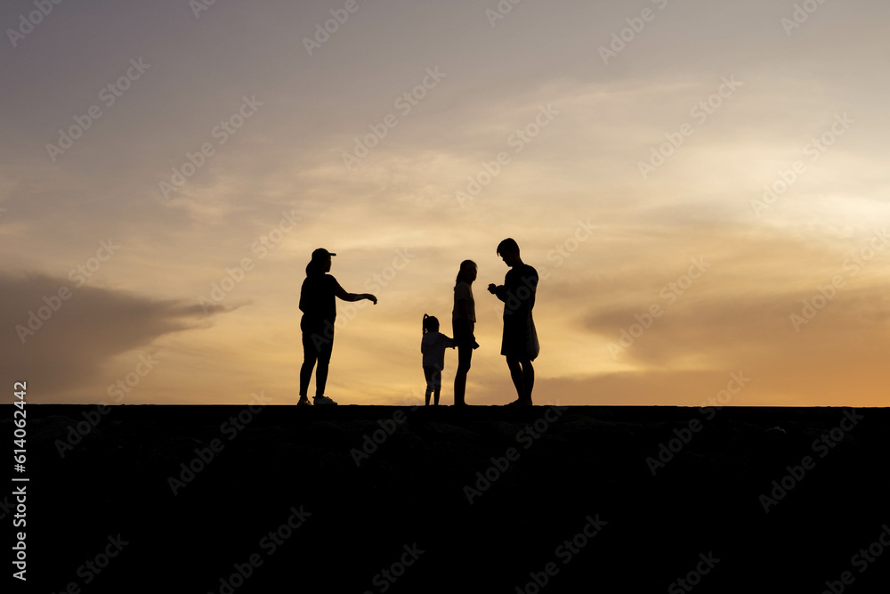 Silhouettes of people on the beach at sunrise