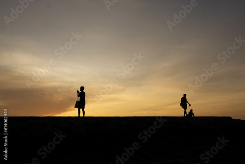 Silhouettes of people on the beach at sunrise