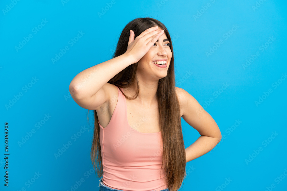 Young caucasian woman isolated on blue background smiling a lot