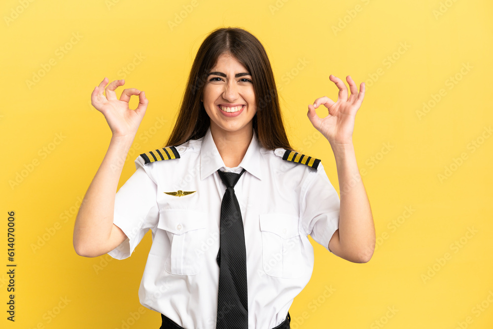 Airplane pilot isolated on yellow background in zen pose Airplane pilot isolated on yellow background in zen pose